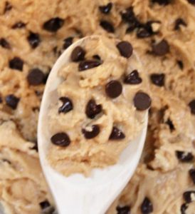 close up of vegan chocolate chip cookie dough on a wooden spoon